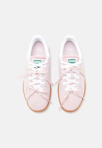Adidași din suede roz deschis cu șireturi albe și accente din panglică roz. Prezintă o branț checker și talpă din cauciuc de culoare caramel. Logo verde pe limbă.