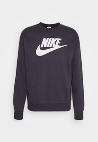 Navy sweatshirt made of cotton blend, featuring a large white Nike logo on the front, ribbed cuffs, and a crew neck design.