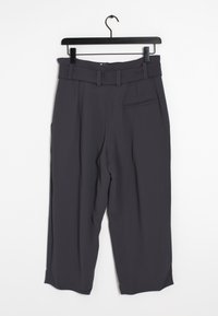 Pantalon gris sur mesure avec ceinture, poches latérales et une texture subtile. Le design présente une coupe droite et des lignes épurées.