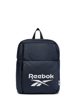 Granatowy plecak Reebok z dużą przednią kieszenią na zamek, czarnymi zamkami, uchwytem do noszenia i białym logo Reebok umieszczonym na środku przedniej kieszeni.