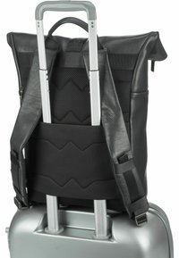 Mochila negra enrollable con correas de cuero texturizado, unida a una maleta plateada. Presenta un respaldo acolchado y correas ajustables.