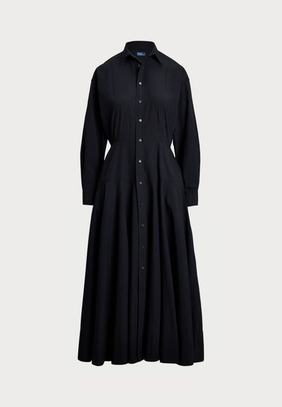 Črna obleka s kratkimi rokavi iz lahkega materiala. Ima ovratnik, dolge rokave, polno krilo in sprednjo zasnovo z gumbi.