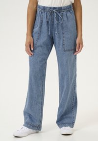 Gaiši zili džinsu bikses ar brīvu piegriezumu, elastīgu jostu un aukliņu, ar priekšējām papildus kabatām un izšuvuma akcentiem.