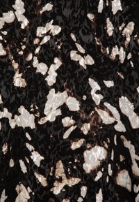 Tessuto nero con un motivo astratto testurizzato che presenta forme marroni e crema. Superficie liscia con una leggera lucentezza.