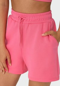 Rosa Baumwollmischung-Shorts mit einem elastischen Bund, Kordelzugdetail, Seitentaschen und einer glatten Textur.