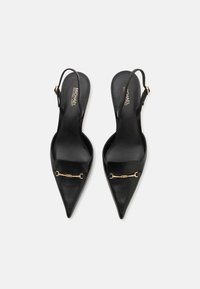 Escarpins à bride arrière en cuir noir avec un bout pointu, accent en métal doré et une texture lisse. Comprend une sangle ajustable pour un bon ajustement.