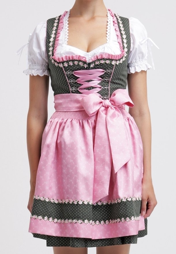 Femme portant une robe traditionnelle allemande dirndl avec une blouse blanche, un corsage vert et un tablier rose noué en un nœud à la taille.
