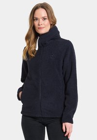 Dunkelblaues Fleece-Jacke mit hohem Kragen, Reißverschluss, Seitentaschen und einem dezenten Logo auf der Brust, aus einem strukturierten, weichen Stoff gefertigt.
