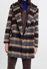 Wollenblend jas met blauwe, grijze en gele strepen, een brede kraag, knoopsluiting aan de voorkant en een rechte snit met een gemêleerde afwerking.