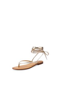 Litte tan-sandaalit, joissa on ohuet metallinväriset kultaketjut ja nilkkasiteet, valkealla taustalla, kulmassa, jotta sivuprofiili näkyy.