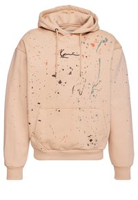 Beige kapucnis pulóver, elülső zsebbel, narancssárga, türkiz és barna fröcskölő mintával. Fekete zsinórok és logó. Puha anyagú.