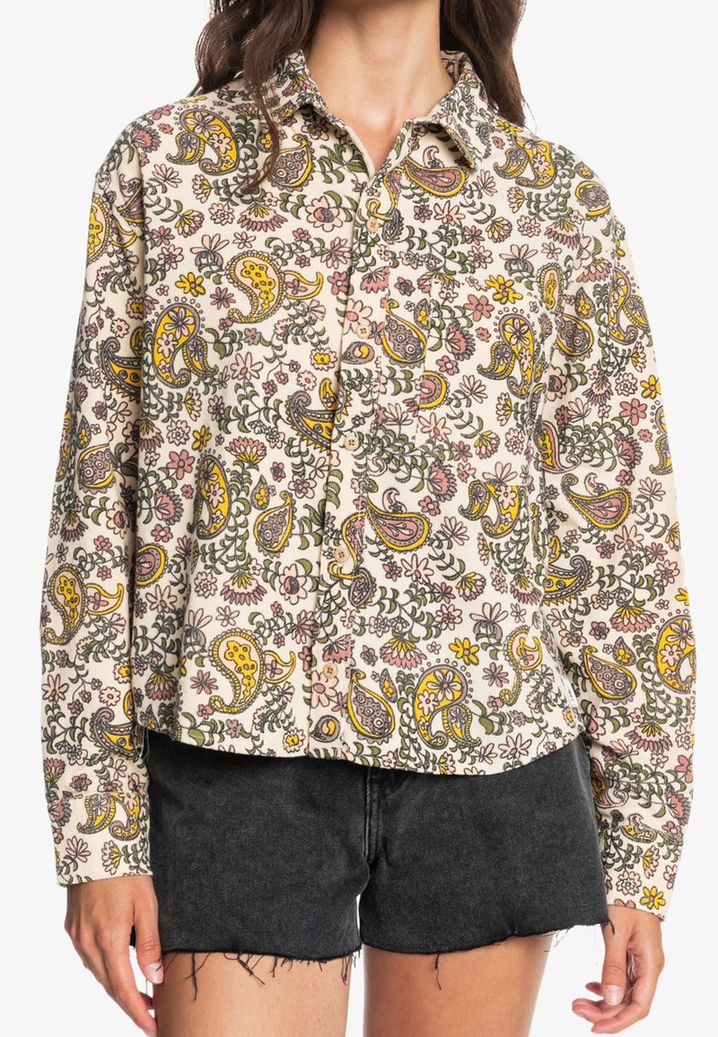 Blommönstrad skjorta med knappar i krämfärg, med paisleymönster i gult, rosa och grått. Långa ärmar med krage och avslappnad passform.