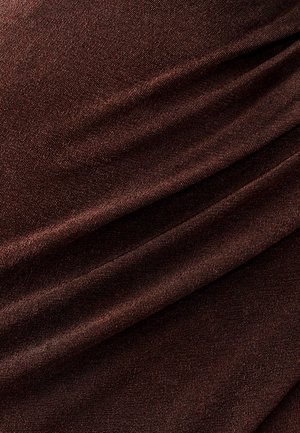 Tessuto marrone con una texture liscia, caratterizzato da sottili linee diagonali e pieghe, che indicano un design morbido e drappeggiato.