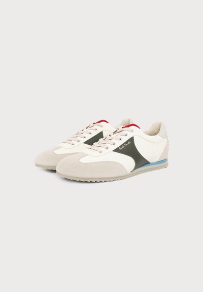 Paire de baskets blanches et beiges avec des panneaux latéraux gris, une doublure intérieure rouge, une bande bleue sur la semelle et un logo "Paul Smith" sur le côté.