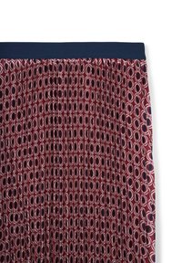 Gonna plissettata con una vita di un blu navy scuro, caratterizzata da un motivo geometrico rosso e bianco con forme ovali sovrapposte e accenti circolari.