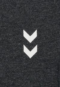 Svart tyg med en texturerad yta och en vit chevron-logotypdesign bestående av två nedåtriktade pilar.