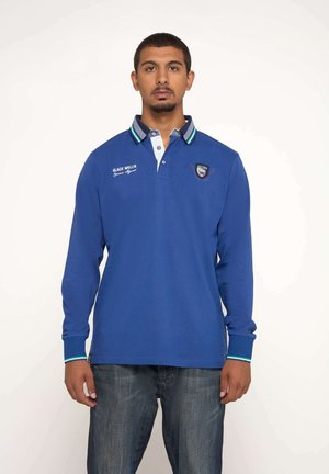 Polo à manches longues de couleur bleue uniforme avec un col et des poignets contrastés présentant des rayures vertes et blanches ; logo de marque sur la poitrine.