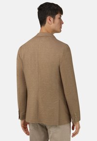 Brązowa teksturowana marynarka o subtelnym wzorze jodełki, z pojedynczym rozcięciem z tyłu oraz srebrnymi guzikami na rękawach.