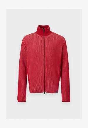 Crveni džemper sa rebrastim uzorkom, zatvaračem, visokim ovratnikom i dugim rukavima, prikazan na jednobojnoj svijetloj pozadini.