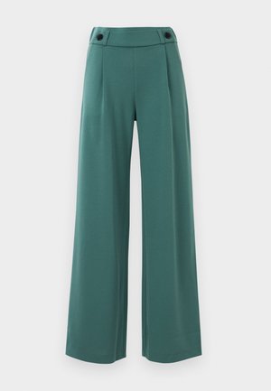 Vidbenade byxor i teal-färgad tyg med en slät yta, med hög midja och två svarta knappar i midjebandet.