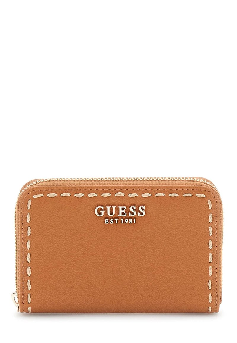 Tan leren ritsportemonnee met witte stiksels. Kenmerkend is het "GUESS EST 1981" logo in metallic afwerking op de voorkant. Compact en rechthoekig ontwerp.