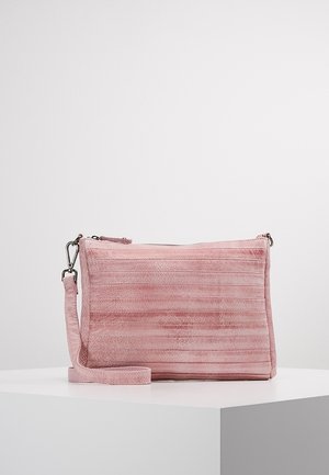Sac bandoulière rectangulaire en daim rose avec surpiqûres horizontales, fermeture éclair et sangle réglable sur une surface blanche.