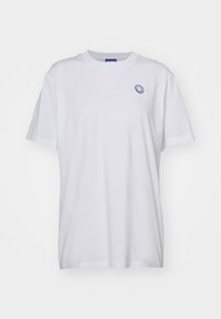Hvid bomulds T-shirt med en afslappet pasform, korte ærmer og et blåt smiley-logo på venstre bryst. Standard runde halsudskæring.