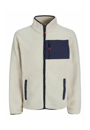 Fleecejack in off-white met een marineblauwe ritsborstzak, zijzakken en contrasterende marineblauwe afwerking langs de rits en manchetten.