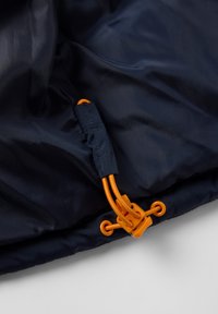 Laine de couleur bleu marine avec une texture lisse, présente un cordon orangé et un fermoir, maintenant le matériau à une extrémité.