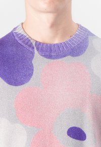 Maglione lavorato a maglia con collo rotondo, caratterizzato da ampi motivi floreali in rosa, viola e grigio. Morbida texture con dettaglio del collo a costine.