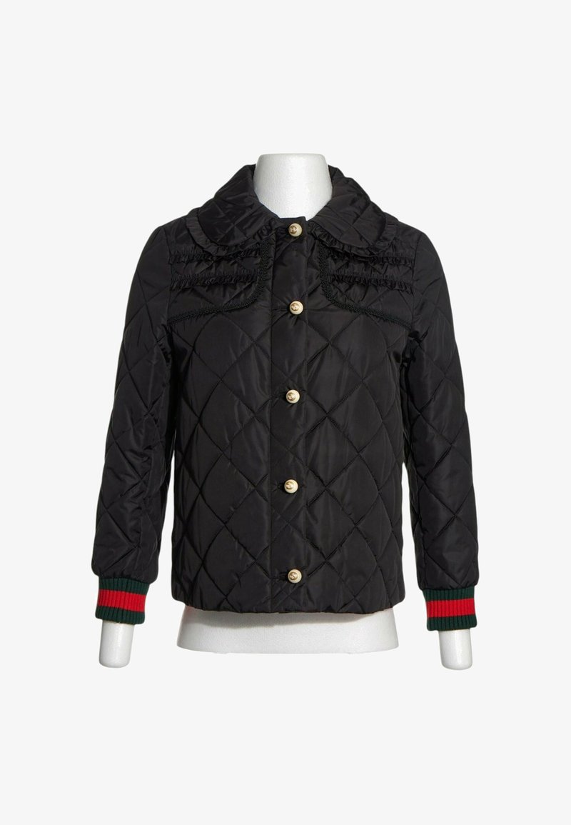 Veste noire matelassée avec boutons en nacre, détails froncés sur la poitrine, large col arrondi et poignets côtelés avec rayures vertes et rouges.