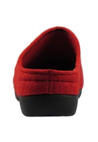 Red felt slipper with a rounded back, black rubber sole, and visible stitching detail along the seams. Smooth texture throughout.