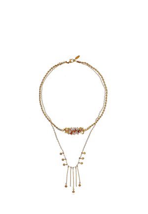 Collier doré superposé avec une chaîne avec de petites perles décoratives et pierres, et une chaîne plus longue avec des pendentifs en forme de disque pendants.
