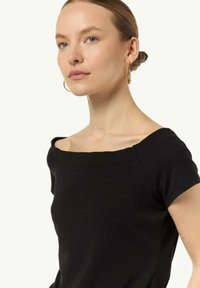 Czarny krótki top z krótkim rękawem i kwadratowym dekoltem, wykonany z gładkiego materiału. Posiada proste linie i minimalistyczne detale przeszyć.