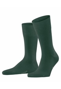 Calcetines verdes hasta la rodilla hechos de un material suave y elástico con un puño acanalado y un mínimo de marcas. Presenta un diseño sin costuras.