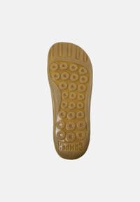 Suela de zapato de goma en marrón claro con un patrón de agarre circular y un borde texturizado. Marca "CAMPPER" visible cerca del área del talón. Talla 42.