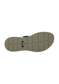 Suola di una scarpa in gomma khaki con un motivo testurizzato e scanalature rettangolari; presenta una toppa nera con il logo "Igleco."