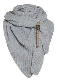 Grijze gebreide sjaal met een ribbelpatroon, zachtjes gedrapeerd. Inclusief een leren label met het merk "Knit Factory". Gezellige textuur en warme uitstraling.