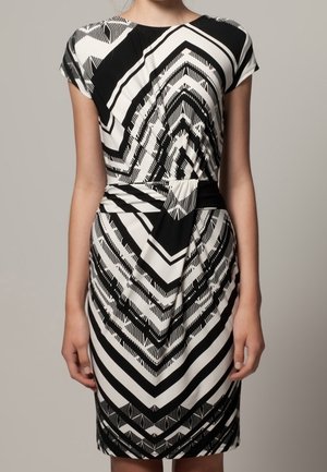 Robe noir et blanc avec un motif en chevrons, des manches courtes, une taille cintrée et une conception à longueur genoux avec une texture drapée.