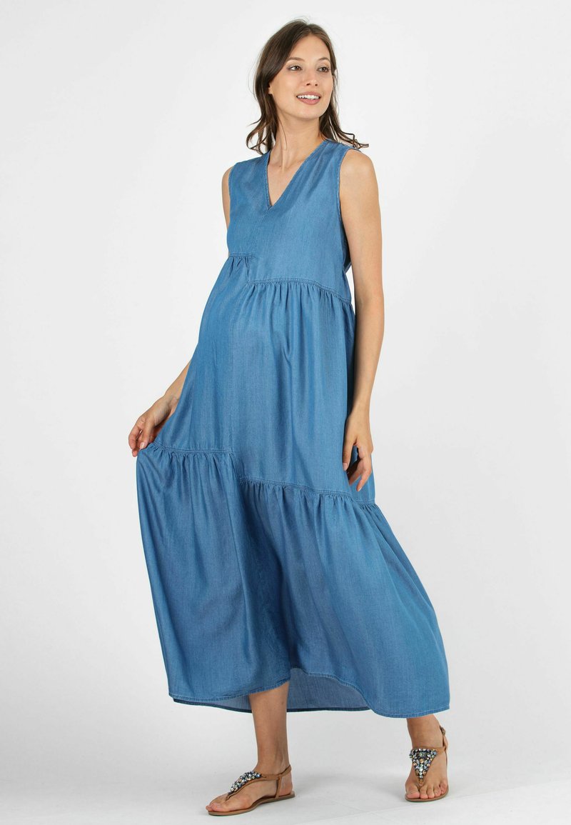Abito maxi in denim con scollo a V e design senza maniche. Presenta dettagli in rouches a strati, una vestibilità comoda e una silhouette lunghezza completa.