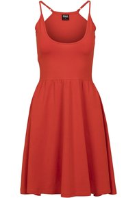 Robe rouge sans manches avec un corsage ajusté et une jupe évasée. Fabriquée en tissu lisse, avec des bretelles fines et un décolleté en forme de cœur.