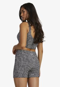 Black and white striped crop top and shorts set, featuring a fitted design, sleeveless top, high waistband, and soft texture.