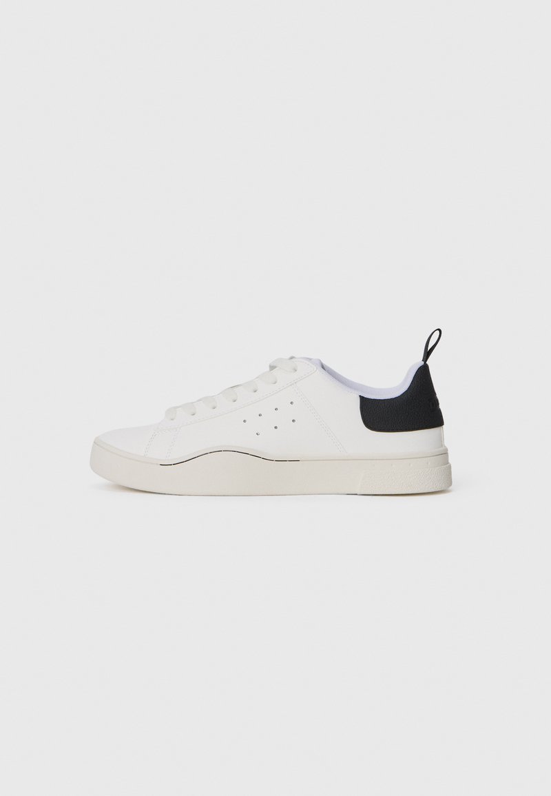 Baskets blanches avec des accents noirs et un talon texturé, présentant un matériau lisse, un bout rond et six œillets pour les lacets.