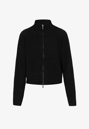 Sudadera negra recortada con cremallera y cuello alto, textura acanalada, mangas largas y detalle de cremallera dorada. Tejido de punto suave para mayor comodidad.