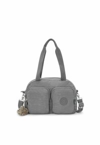 Bolso de tela gris con dos bolsillos frontales, forma redondeada, doble asa, correa ajustable y un pequeño charm de mono adjunto.