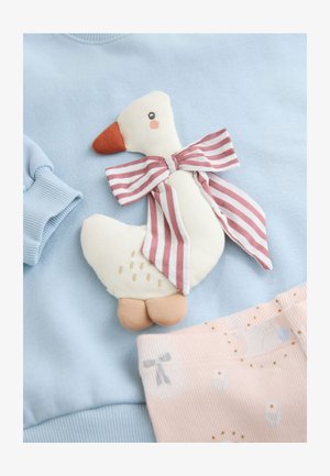 Sweatshirt bleu clair avec une application en forme d'oie en peluche portant un nœud papillon rayé. L'oie a un corps beige, un bec orange et des pieds marron.