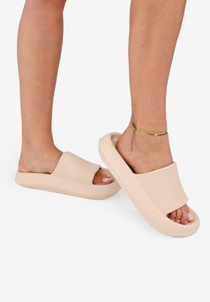 Sandali a infradito beige con upper testurizzato, design aperto sulla punta e suola spessa. Presentano una fascia ampia e una finitura liscia.