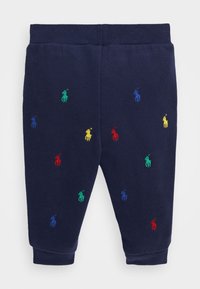 Pantalons de survêtement bleu marine en tissu doux, ornés de logos de polo brodés multicolores en jaune, rouge, vert et bleu, avec des poignets côtelés.
