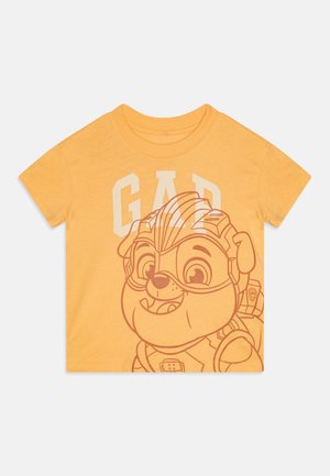 Geel katoenen t-shirt met korte mouwen, waarop een grote afbeelding van een cartoonpersonage staat, met daarboven de tekst "GAP" in een vet, lichtgekleurde lettertype.