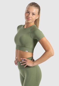 Olijfgroen atletisch cropped top met korte mouwen, naadloos ontwerp, geribbelde zoom, gecombineerd met bijpassende high-waisted leggings.